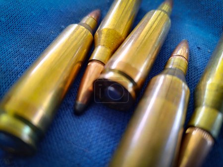 Top view shot new shotgun cartridges over blue fabric background