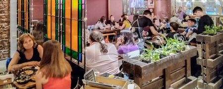 Téléchargez les photos : Trelew, Argentine ; 27 décembre 2022 : Crowded resto bar interior night scene at trelew city, chubut, argentina - en image libre de droit