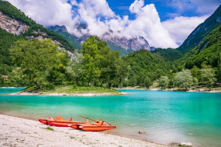 Téléchargez les photos : Incroyable beau lac turquoise Tenno dans la région du Trentin en Italie, entouré par les montagnes des Alpes. vue panoramique avec minuscule île et canot - en image libre de droit