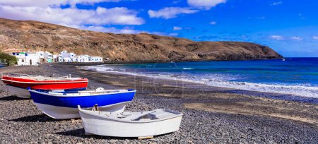 Foto de Lugares escénicos de la isla de Fuerteventura. Encantador pueblo de pescadores Pozo Negro con coloridos barcos antiguos en la playa. Islas Canarias - Imagen libre de derechos