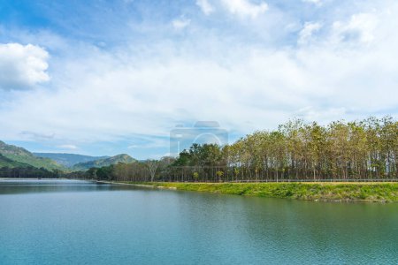 Photo for Beautiful and peaceful view of large reservoir with surrounding mountain and trees in beautiful sunshine and cloudy sky in Thailand. Tranquil and beautiful natural scenery landscape of reservoir lake. - Royalty Free Image