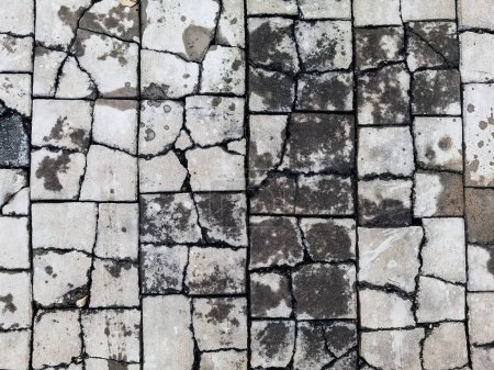 Photo for Top view texture of the brick blocks floor in the cracks. The surface of the public outdoor walkway or pavement is broken and damaged. Cracked brick, Close up Damaged cement pathway floor background. - Royalty Free Image