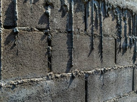 Photo for Dry cement drips on bricks wall. Mortar dripping and running down the finished brick wall. Surface and textured of cement wall. Unwhitewash block brick wall with cement drip. Stains of cement on wall. - Royalty Free Image