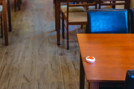 Photo for Pager device for ordering food on wooden table in restaurant. Wireless restaurant pager caregiver pager wireless call system. Queue paging wireless calling system. Button transmitter calling system. - Royalty Free Image