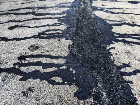 Photo for Asphalt on road. Street with black tar filling the cracks. Cracks in concrete surface are then filled with asphalt. Texture of old asphalt road. Asphalt is covered with cracks, which filled with tar. - Royalty Free Image