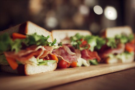 Foto de Ilustración de alimentos - sándwiches de tocino y ensalada como aperitivo en una bandeja de madera. - Imagen libre de derechos