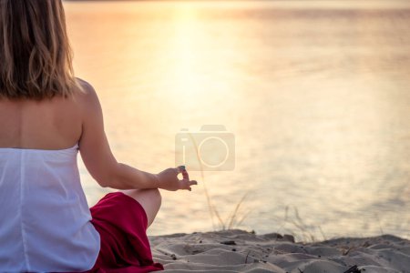 serenidad y yoga practicando en el mar. puesta de sol