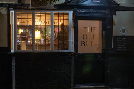 Foto de Sawbridgeworth, Hertfordshire / Inglaterra 13 de septiembre de 2022: El pub Old Bell en la calle Bell en Sawbridgeworth, una vista nocturna a través de la ventana frontal del propietario que sirve - Imagen libre de derechos