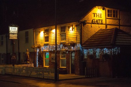 Foto de Sawbridgeworth, Hertfordshire Inglaterra-10 de diciembre de 2022: Una vista nocturna de la calle de la Puerta. The Gate Pub es un pub tradicional ubicado en las fronteras de Herts / Essex, en el pueblo de Sawbridgeworth.. - Imagen libre de derechos