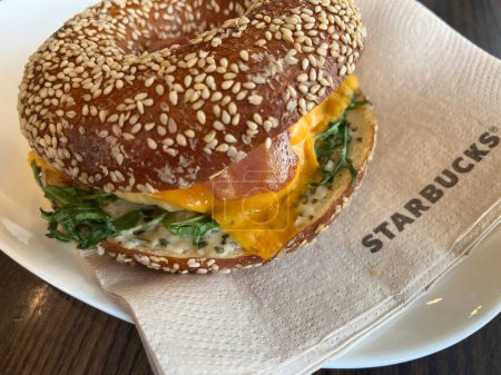 Foto de NUREMBERG, ALEMANIA - 17 DE MAYO DE 2023: Hamburguesa de desayuno en Starbucks con bagel tradicional alemán - Imagen libre de derechos