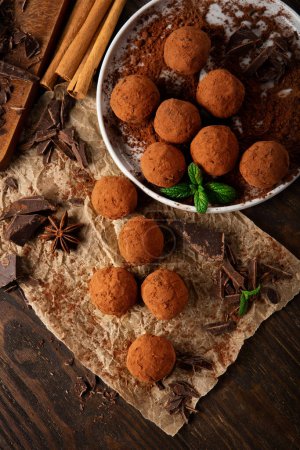 Photo for Homemade vegan chocolate truffles, round chocolate candies,  with cocoa powder. Dark Chocolate and Coconut Butter on rustic wooden background. Handmade, Gluten free, Healthy dessert concept. - Royalty Free Image