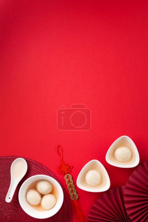 Photo for Sweet rice dumplings balls Tang Yuan for Chinese Dongzhi festival and lunar new year festival food. Winter Solstice day concept on red background. Top view, copy space. - Royalty Free Image
