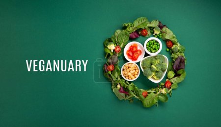Mois de régime végétarien et végétalien en janvier appelé Veganuary. Variété d'aliments végétaliens à base de protéines végétales, légumes crus sains. Vue du dessus sur fond vert.