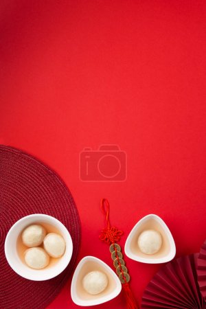 Süße Reisknödel Bällchen Tang Yuan für chinesisches Fest- und Mondfest-Essen. Wintersonnenwende-Konzept auf rotem Hintergrund. Ansicht von oben, Kopierraum.