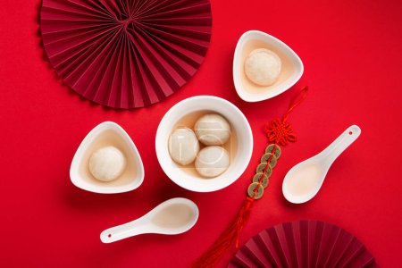 Süße Reisknödel Bällchen Tang Yuan für chinesisches Fest- und Mondfest-Essen. Wintersonnenwende-Konzept auf rotem Hintergrund. Ansicht von oben, Kopierraum.
