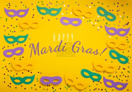 Photo for Mardi Gras gold color beads with Masquerade festival carnival masks and golden, green, purple confetti on yellow background. Party invitation, greeting card, venetian carnivale celebration concept. - Royalty Free Image
