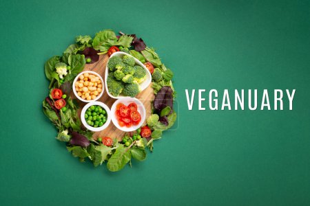 Dieta vegetariana y vegana mes en enero llamado Veganuary. Variedad de vegano, alimentos a base de proteínas vegetales, verduras crudas saludables. Vista superior sobre fondo verde.