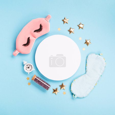 World Sleep day observed on March. Quality of sleep, good night, insomnia, relaxation concept. Sleeping masks, golden stars and white alarm clock on blue background. Flat lay, top view