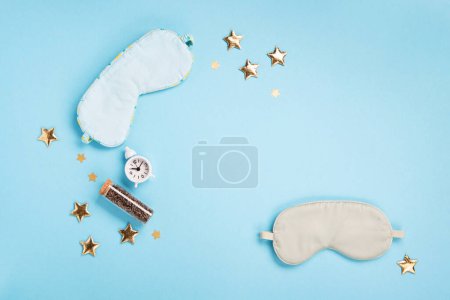 Photo for World Sleep day observed on March. Quality of sleep, good night, insomnia, relaxation concept. Sleeping masks, golden stars and white alarm clock on blue background. Flat lay, top view - Royalty Free Image