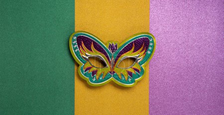 Mardi Gras masquerade festival carnival mask on green, golden, purple background. Holiday party invitation, greeting card concept.