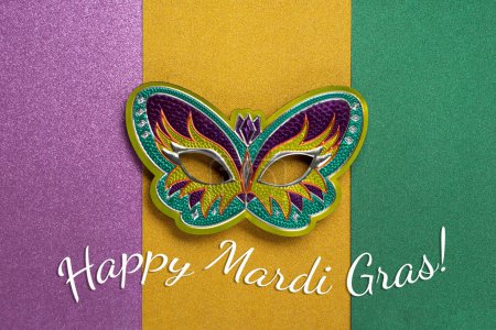 Photo for Mardi Gras masquerade festival carnival mask on green, golden, purple background. Holiday party invitation, greeting card concept. - Royalty Free Image