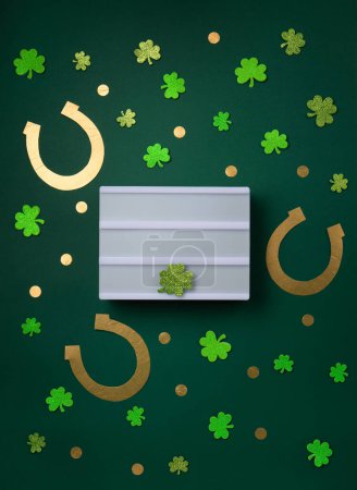 Photo for St. Patrick's Day celebration Concept. Greeting card with traditional symbols - Golden horseshoes, gold coins and clover leaves, green shamrocks on green background. Top view, copy space. - Royalty Free Image