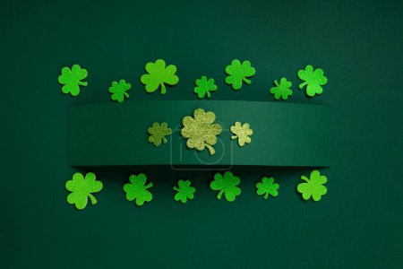 Foto de St. Patrick's Day celebration Concept. Greeting card with traditional symbols - clover leaves or green shamrocks on green background. Top view, copy space. - Imagen libre de derechos