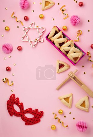 Photo for Purim celebration jewish carnival holiday concept. Tasty hamantaschen cookies, Triangular pastry, red carnival mask, noisemaker, sweet candies and party decor on pink background. Top view, flat lay, copy space. - Royalty Free Image