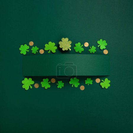 Téléchargez les photos : St. Patrick's Day celebration Concept. Greeting card with traditional symbols - Golden horseshoe, gold coins and clover leaves, green shamrocks on green background. Top view, copy space. - en image libre de droit