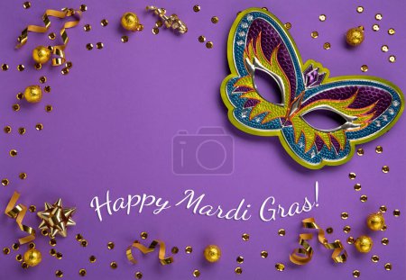 Photo for Mardi Gras masquerade festival carnival mask, sweet chocolate candies, gold beads and golden confetti on purple background. Holiday party invitation, greeting card concept, cope space - Royalty Free Image