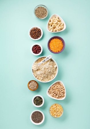 Photo for Plant based protein food (legumes, lentils, beans, seeds) and Healthy dry Pea Protein Powder, food supplement, Fitness nutrition on blue green background. Vegan, vegetarian food concept. - Royalty Free Image