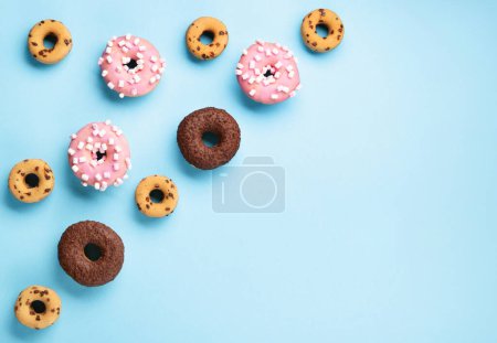 Photo for Happy National donut day Concept. Donuts doughnuts with chocolate, marshmallow and sugar sprinkles on blue background, copy space. Colorful carnival or birthday party card. - Royalty Free Image