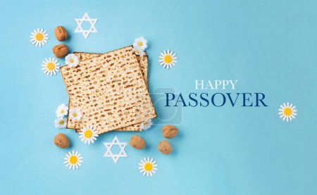 Photo for Jewish holiday Passover greeting card concept with matzah, nuts and daisy flowers on blue table. Seder Pesach spring holiday background, top view, copy space. - Royalty Free Image