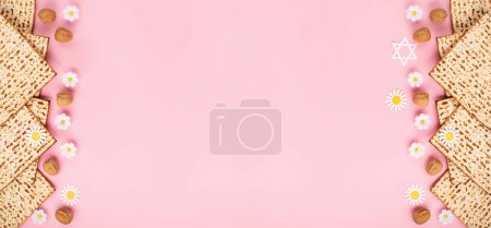 Photo for Jewish holiday Passover greeting card concept with matzah, nuts and daisy flowers on pink backgrouns. Seder Pesach spring holiday background, top view, copy space. - Royalty Free Image
