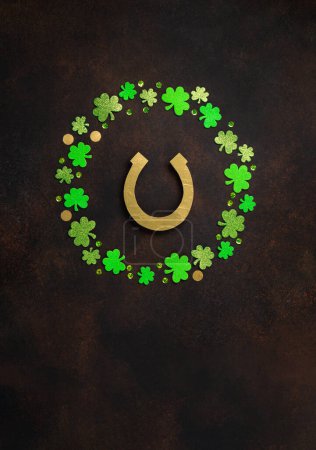 Photo for St. Patrick's Day celebration Concept. Greeting card with traditional symbols - Golden horseshoe, gold coins and clover leaves, green shamrocks on dark brown wooden background. Top view, copy space. - Royalty Free Image