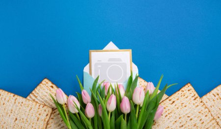Téléchargez les photos : Juif vacances Pessah concept de carte de voeux avec matzah, noix, fleurs de tulipes sur table bleue Seder Pessah printemps vacances arrière-plan, vue du dessus, espace de copie. - en image libre de droit