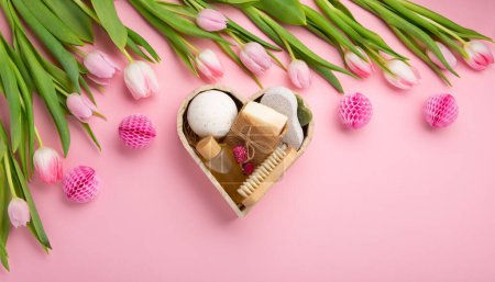 Photo for Natural eco friendly beauty skin care products, spa accessories for women and spring tulip flowers on pink background. Zero waste self care heart shape gift box for mothers day, womans day, birthday. - Royalty Free Image