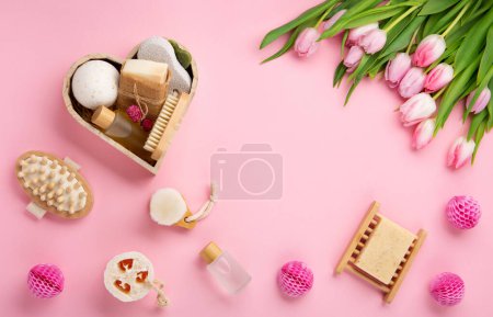 Foto de Natural eco friendly beauty skin care products, spa accessories for women and spring tulip flowers on pink background. Zero waste self care heart shape gift box for mothers day, womans day, birthday. - Imagen libre de derechos