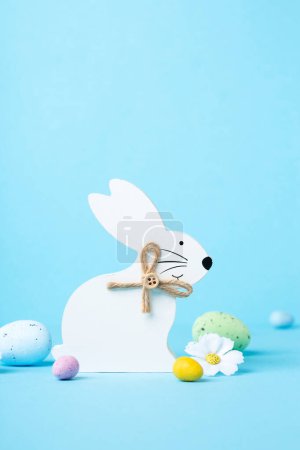 Photo for White  Easter Bunny, Sweet Colorful Easter Eggs, daisy flowers on pastel blue background. Happy Easter greeting card concept, copy space. - Royalty Free Image