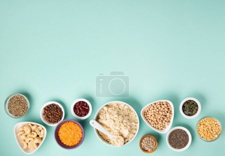 Photo for Plant based protein food (legumes, lentils, beans, seeds) and Healthy dry Pea Protein Powder, food supplement, Fitness nutrition on blue green background. Vegan, vegetarian food concept. - Royalty Free Image