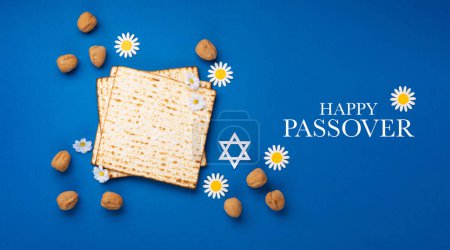 Photo for Jewish holiday Passover greeting card concept with matzah, nuts, spring flowers on blue table. Seder Pesach spring holiday background, top view, copy space. - Royalty Free Image