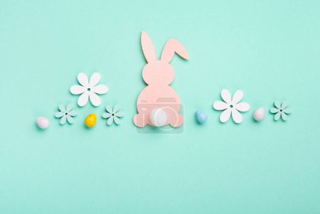 Téléchargez les photos : Pink Easter Bunny, Sweet Colorful Easter Eggs, daisy flowers on pastel blue background. Happy Easter greeting card concept, copy space. - en image libre de droit