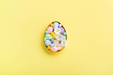 Photo for Sweet Colorful Easter Eggs and spring white daisy flowers on pastel yellow background. Happy Easter greeting card concept. Flat lay, top view, copy space. - Royalty Free Image