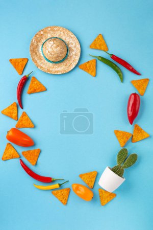 Photo for Mexican background fiesta with Traditional Mexican nachos chips, chilli pepper, cactus and sombrero hat on blue background. Cinco de Mayo (Fifth of May) celebration concept. Top view, copy space. - Royalty Free Image