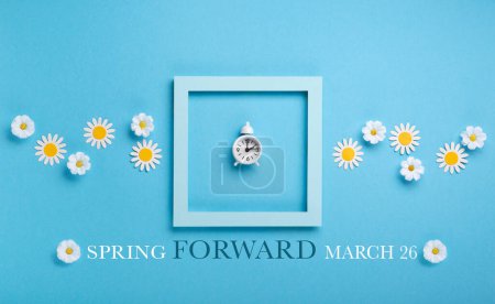 Foto de White alarm clock and Daisy Flowers on blue background. Spring forward, Time Change, Daylight Saving Time Ends, Changing the time on the watch to spring time, Summer back concept. - Imagen libre de derechos