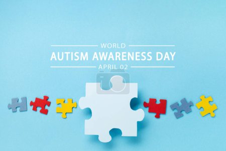Téléchargez les photos : Journée mondiale de sensibilisation à l'autisme ou concept de mois. Design créatif pour le 2 avril. Puzzle de couleur, symbole de sensibilisation au trouble du spectre autistique sur fond bleu. Vue du dessus, espace de copie pour le texte. - en image libre de droit