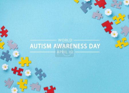 Photo for World Autism Awareness Day or month concept. Creative design for April 2. Color puzzle, symbol of awareness for autism spectrum disorder and daisy flowers on blue background. Top view, copy space for text. - Royalty Free Image