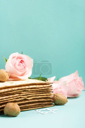 Foto de Fiesta judía concepto de tarjeta de felicitación Pascua con matzá, Estrella de David, flores de primavera, nueces en la mesa de menta azul. Seder Pesaj fondo de vacaciones de primavera, espacio de copia. - Imagen libre de derechos
