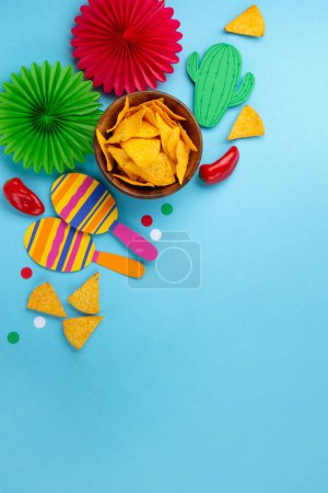 Photo for Mexican background fiesta with Traditional Mexican nachos chips, red chilli pepper, cactus and maracas on blue background. Cinco de Mayo (Fifth of May) celebration concept. Top view, copy space. - Royalty Free Image