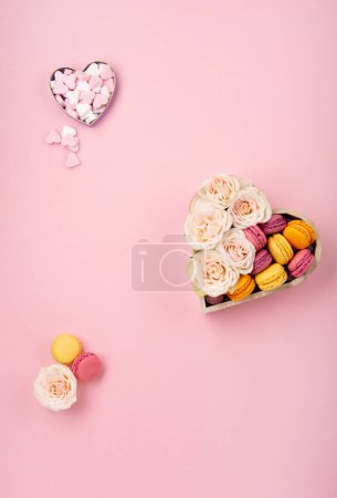Photo for Sweet cookies macaroons in festive gift box, rose flowers and candies on pink background. Holiday presents concept for Mothers day, womans day valentines day, birthday. Top view, copy space. - Royalty Free Image